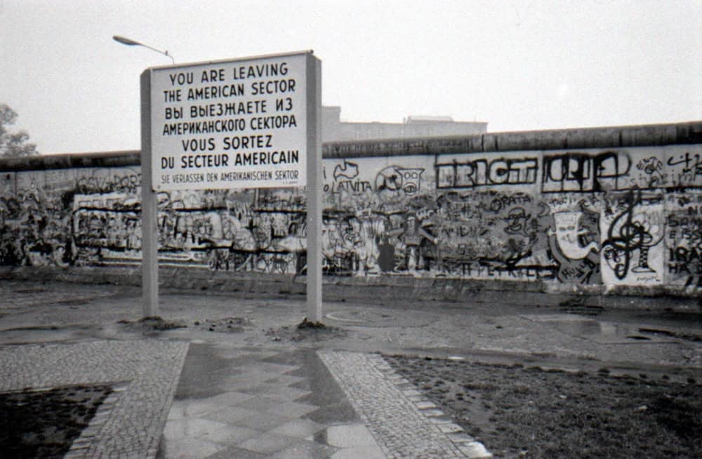 Berlin Duvarı, 13 Ağustos 1961 ile 9 Kasım 1989 arasında Almanya’nın başkenti Berlin’i ikiye bölen fiziksel ve ideolojik bir sınırdı. Soğuk Savaş döneminin sembolü hâline gelen bu yapı, sosyalist Alman Demokratik Cumhuriyeti (DDR) ile kapitalist Federal Almanya Cumhuriyeti (BRD) arasındaki derin ayrımı somutlaştırmıştı. İnşası ve yıkılışı, Almanya’nın ve dünyanın tarihinde derin izler bıraktı. Peki, Berlin Duvarı tam olarak neydi? Neden inşa edildi ve Alman toplumunu nasıl etkiledi?