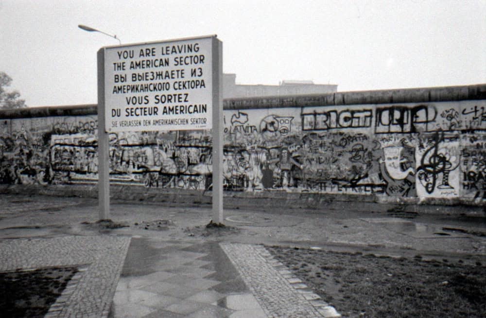 Berlin Duvarı, 13 Ağustos 1961 ile 9 Kasım 1989 arasında Almanya’nın başkenti Berlin’i ikiye bölen fiziksel ve ideolojik bir sınırdı. Soğuk Savaş döneminin sembolü hâline gelen bu yapı, sosyalist Alman Demokratik Cumhuriyeti (DDR) ile kapitalist Federal Almanya Cumhuriyeti (BRD) arasındaki derin ayrımı somutlaştırmıştı. İnşası ve yıkılışı, Almanya’nın ve dünyanın tarihinde derin izler bıraktı. Peki, Berlin Duvarı tam olarak neydi? Neden inşa edildi ve Alman toplumunu nasıl etkiledi?